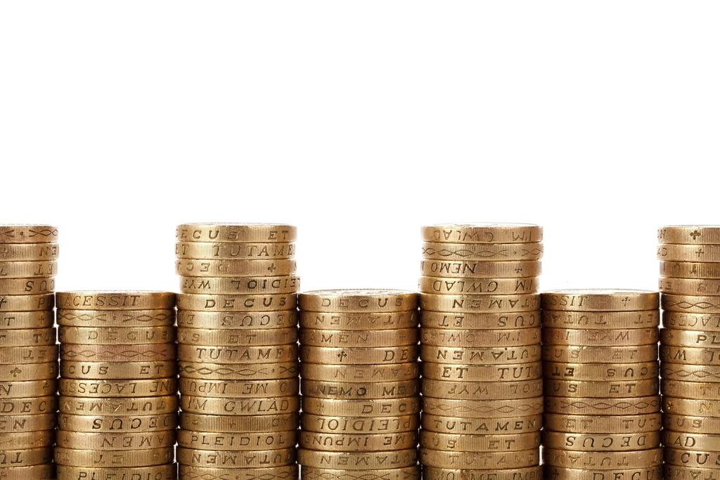 Several neat stacks of coins against a plain background.